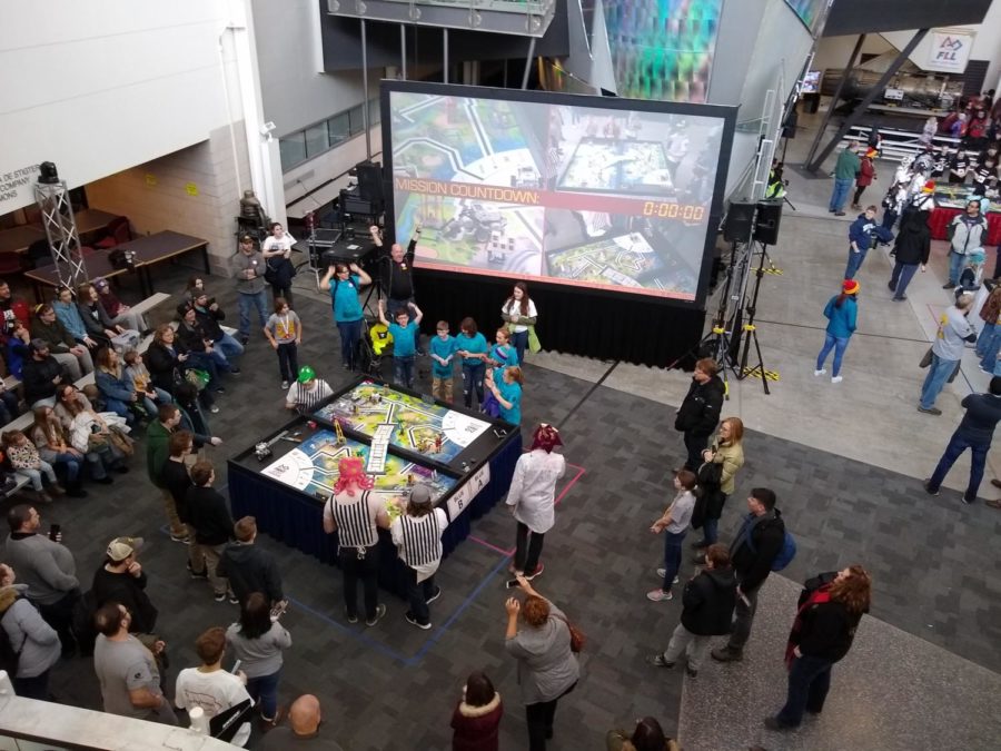People watch as the robots attempt a variety of tasks at the FIRST LEGO League championships.