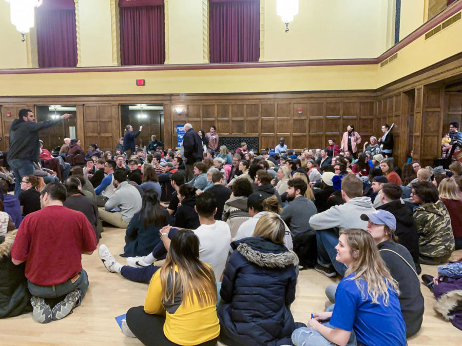 Students and community members gathered to caucus Monday in the Sun Room of the Memorial Union.
