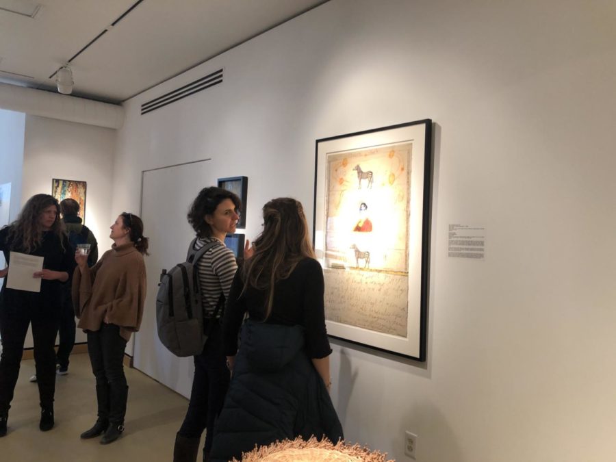 Attendees of the #WomenKnowStuffToo exhibition reception view various works of art by women artists.