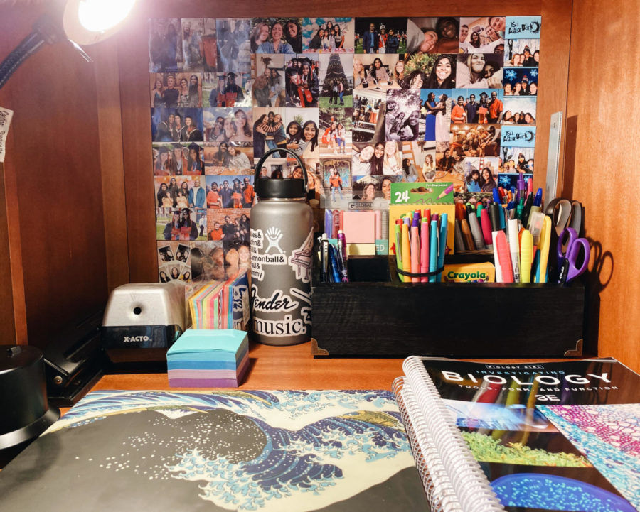 Durga Sritharan, a freshman in biology, uses her desk at home to work on classwork. She has created a wall of photos with her friends and family to create a less stressful environment. 