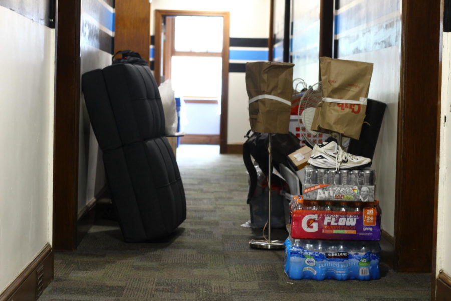 Piles of belongings sit in a dorm hallway as students and families work to move things into their new on-campus homes. 