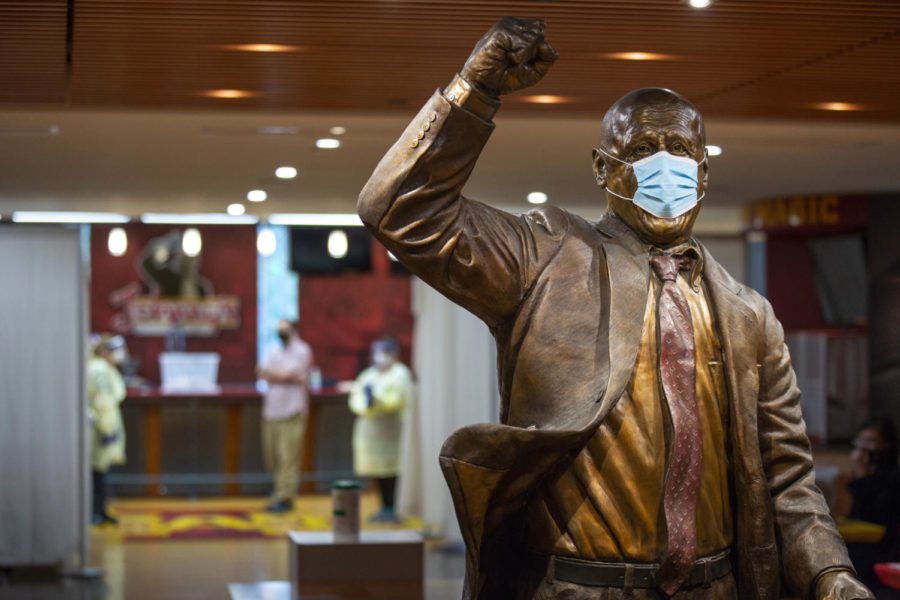 A masked Johnny Orr statue stands in the intake area while testers wait at Iowa State University’s COVID-19 testing center inside Johnny’s at Hilton Coliseum. 