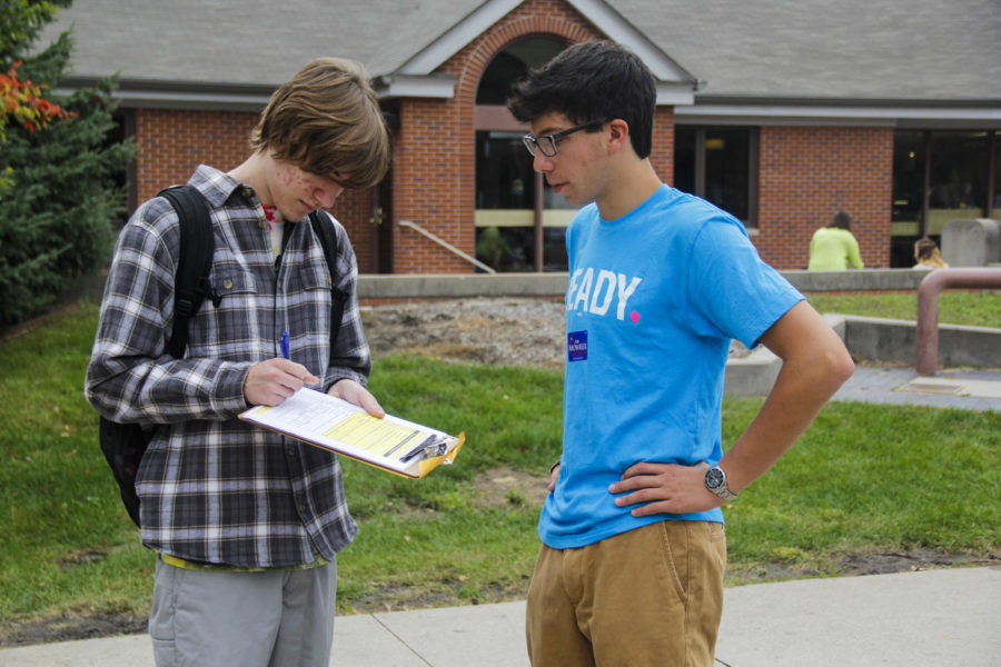 Evan Abramsky, then-sophomore (right), helps Nick Shipley, then-freshman (left), register to vote in Story County, Iowa, in the free-speech zone in front of Parks Library on Sept. 25, 2014.