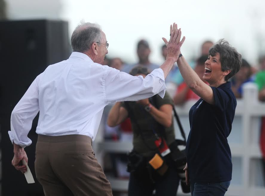 Sen. Chuck Grassley and Sen. Joni Ernst high-five each other during Jonis Roast and Ride event at Central Iowa Expo Ground on June 6, 2015, in Boone, Iowa. The two senators would have a vote in the trial to convict President Donald Trump should the House of Representatives impeach him.