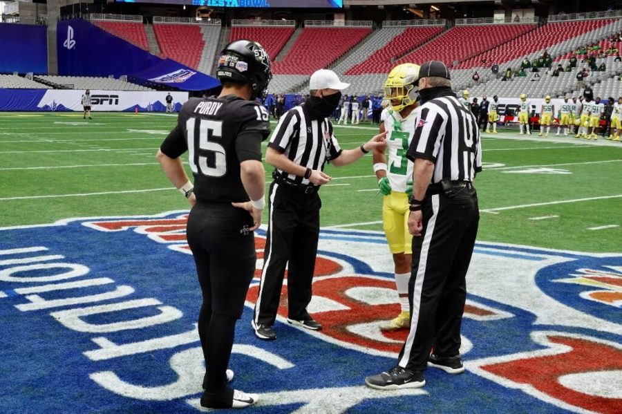 Iowa State quarterback Brock Purdy and Oregon wide receiver Johnny Johnson meets with officials at midfield for the coin toss in the 2020 PlayStation Fiesta Bowl.(Photo courtesy of PlayStation Fiesta Bowl/Slingshot Photography)