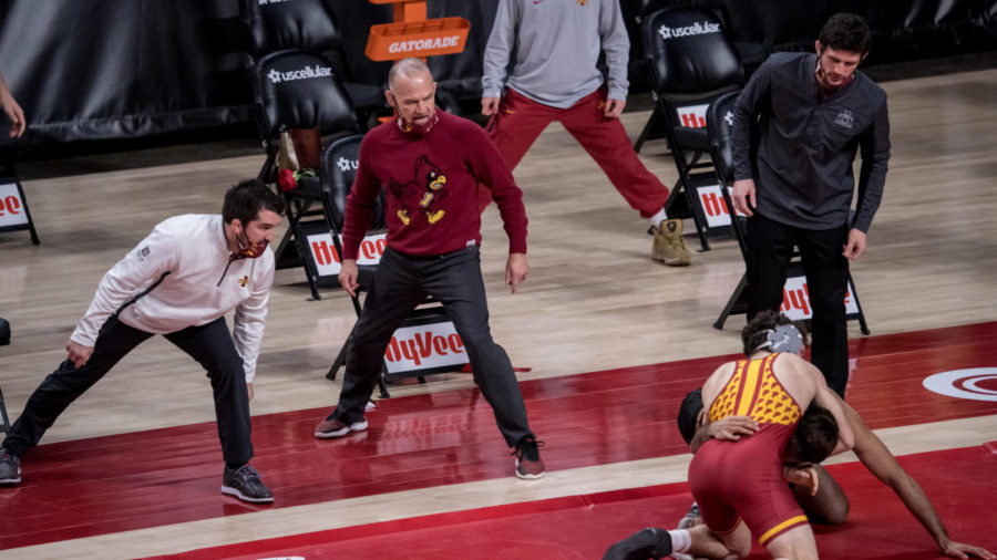 Iowa State Head Coach Kevin Dresser (middle) and assistant coaches Brent Metcalf (left) and Derek St. John (right) look on as Iowa State's Isaac Judge wrestles Anthony Valencia of Arizona State on Feb. 14.