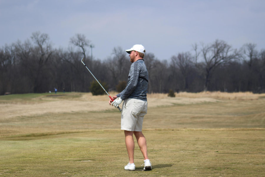 Tripp Kinney watches where his ball goes after a chip onto the practice green April 5, 2019.