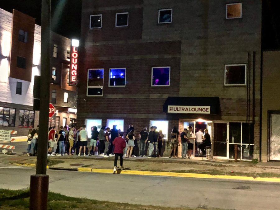 Students, sporting few masks and no social distancing, lined up to enter AJs Ultra Lounge on Oct. 9 during the first weekend of reopened bars in Story County.