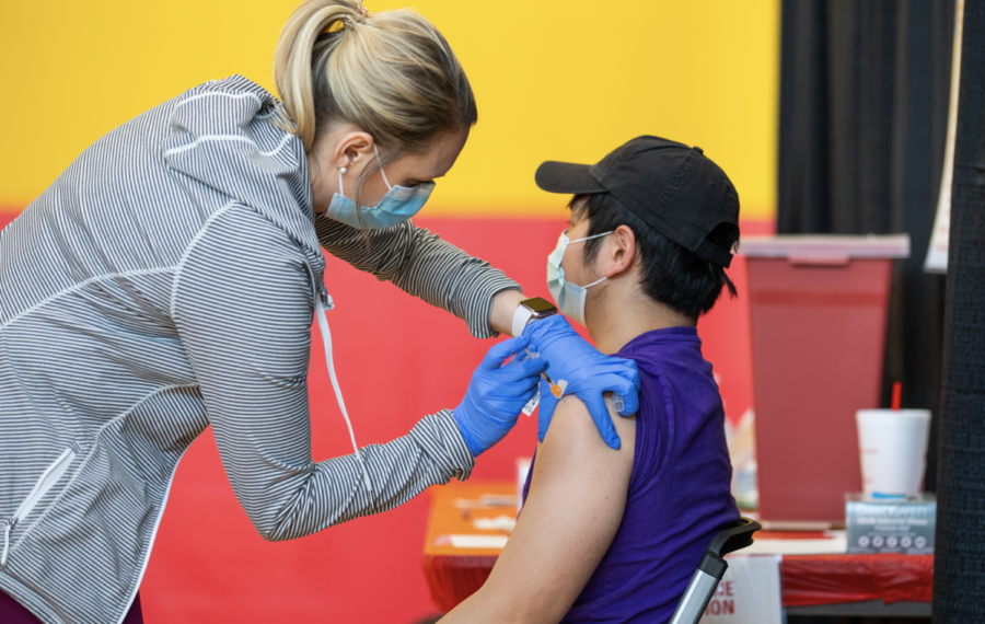 Senior Yoong Tsin Ong of Kuala Lumpur, Malaysia, receives his vaccination from vaccinator Kori Grooms at a COVID-19 vaccination clinic at State Gym on April 2.