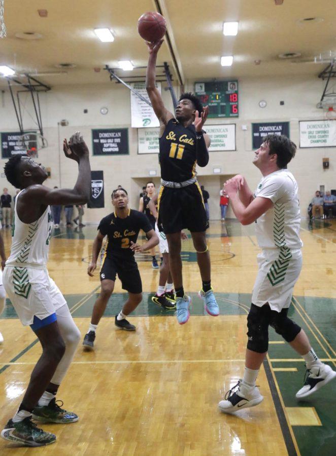 Guard Tyrese Hunter (11) hits a short jumper against forwards Alex Antetokounmpo (24) and Ben Jelacic (32) during the prep basketball game between Dominican High School and Racine St. Catherines on Feb 16.