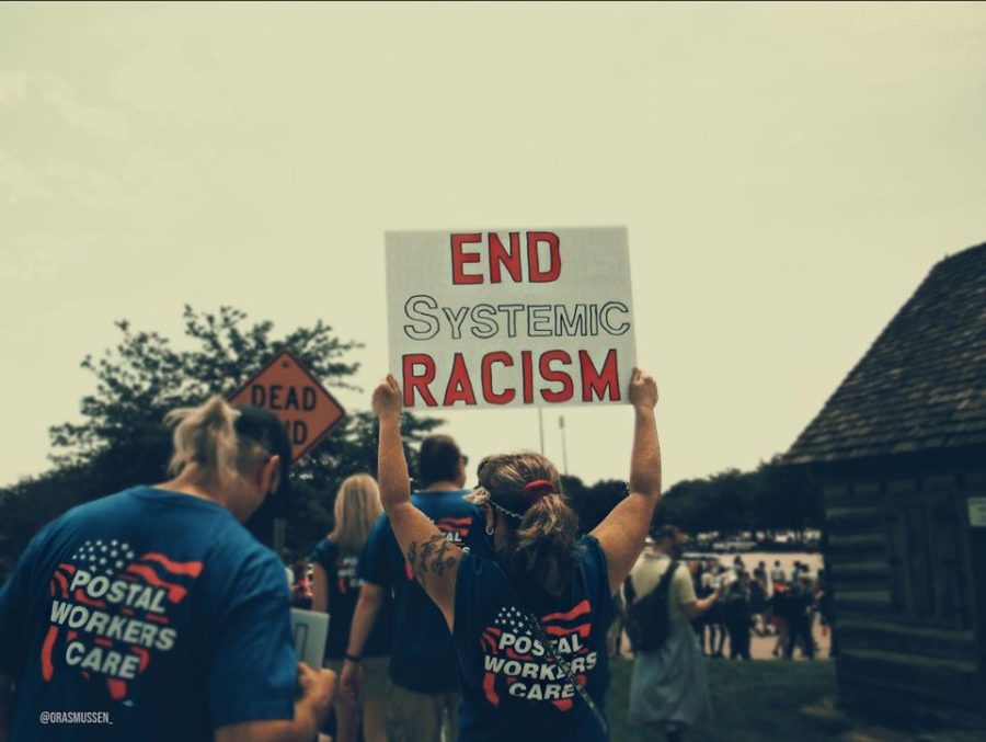 Postal workers holding an End Systemic Racism sign at the BLM Unity March and Rally in Des Moines, Iowa. 