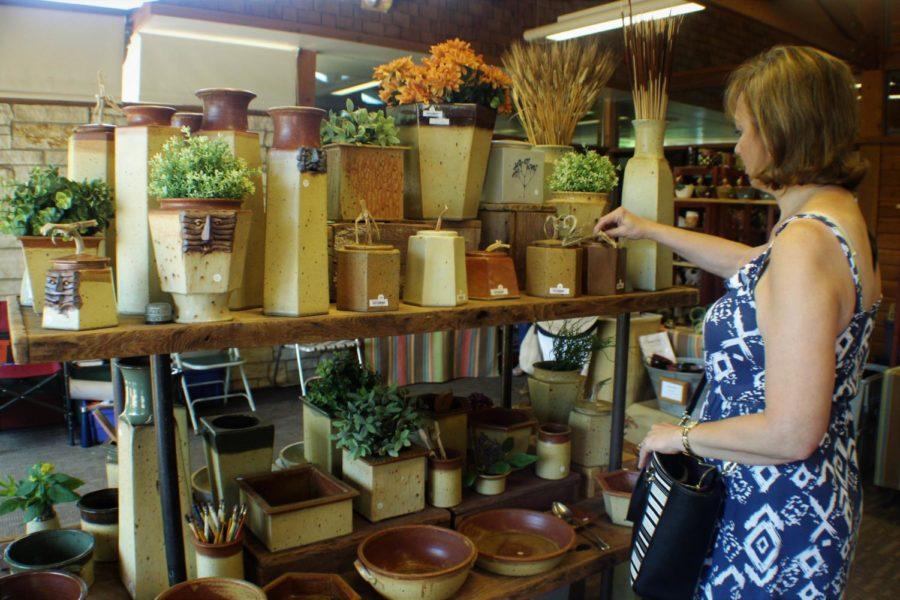 A shopper looked at pottery during the 2017 Garden Art Fair at Reiman Gardens.