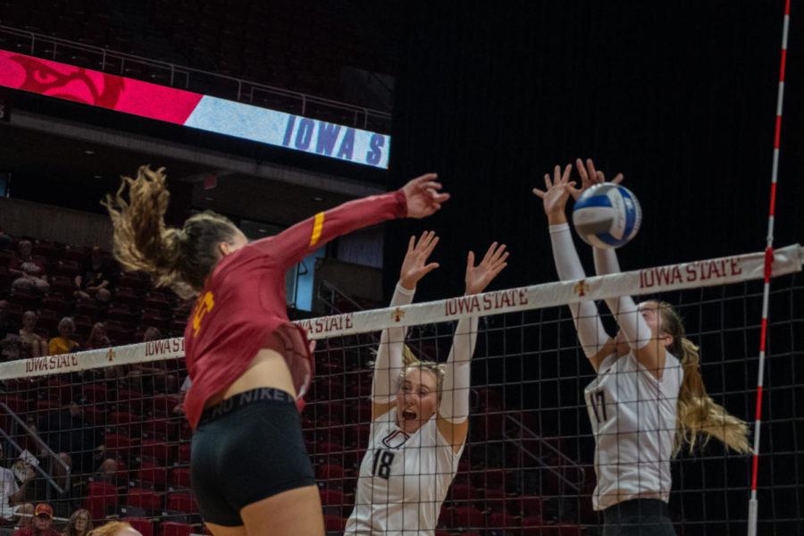 Annie Hatch is seen spiking the ball into a wall of Omaha defenders
