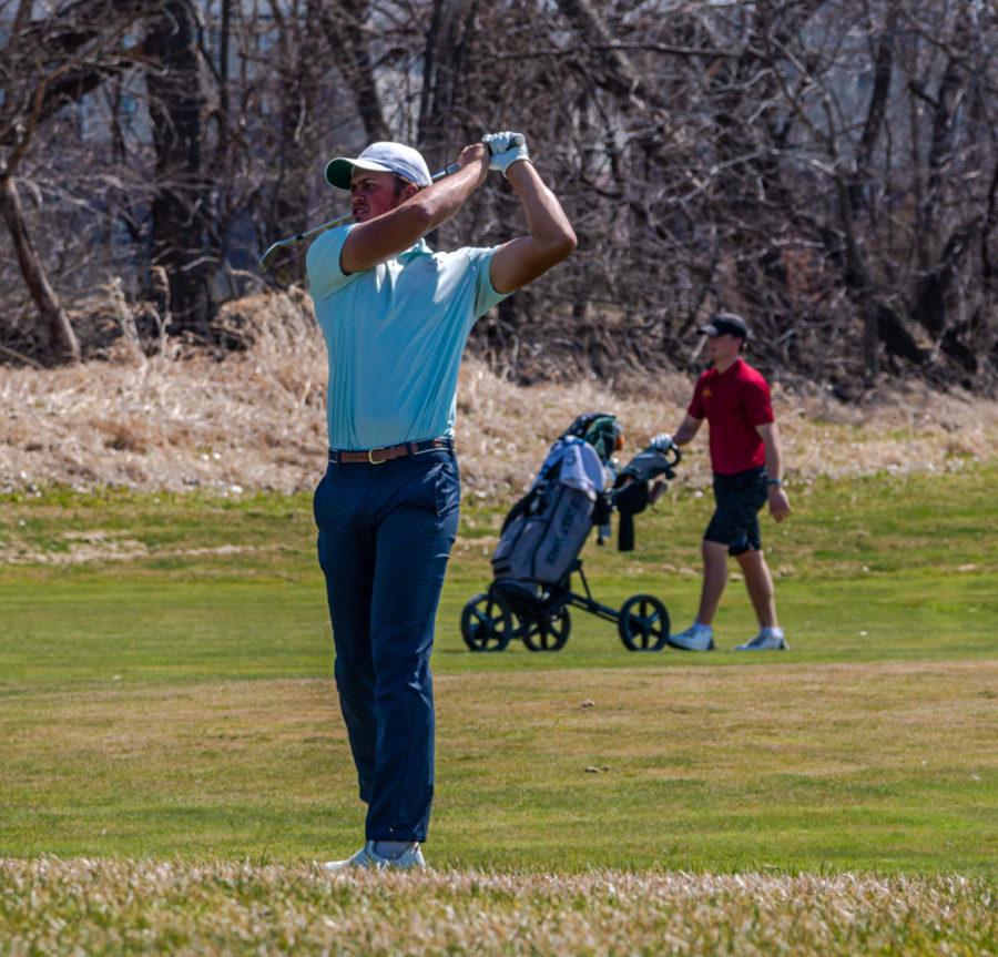 Then junior Ricky Costello watches the flight of the ball after a chip at Coldwater Golf Links April 3.