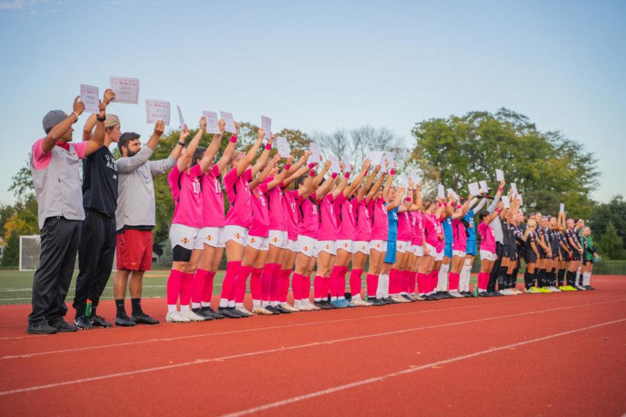 Iowa State and Texas Tech soccer players and coaches hold up signs of people they know who have had breast cancer during Pink Night on Oct. 14.