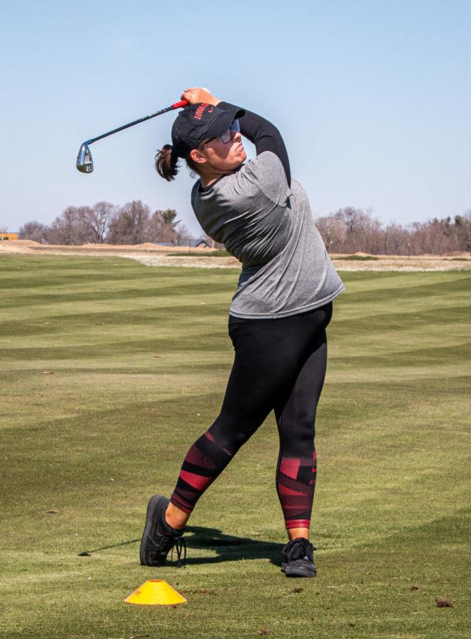 Sophomore golfer Charley Jacobs watches the flight of the ball during a chipping drill April 5 at the Cyclone Sports Complex. The Australian native finished her prep career in the top 500 in the World Amateur Golf Rankings.