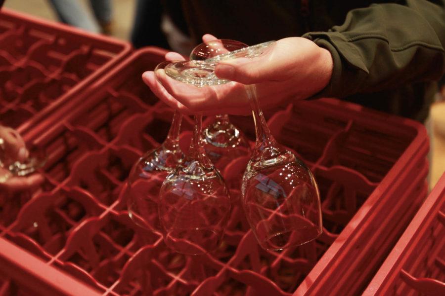 A student picks out wine glasses to use to taste different American white wines.