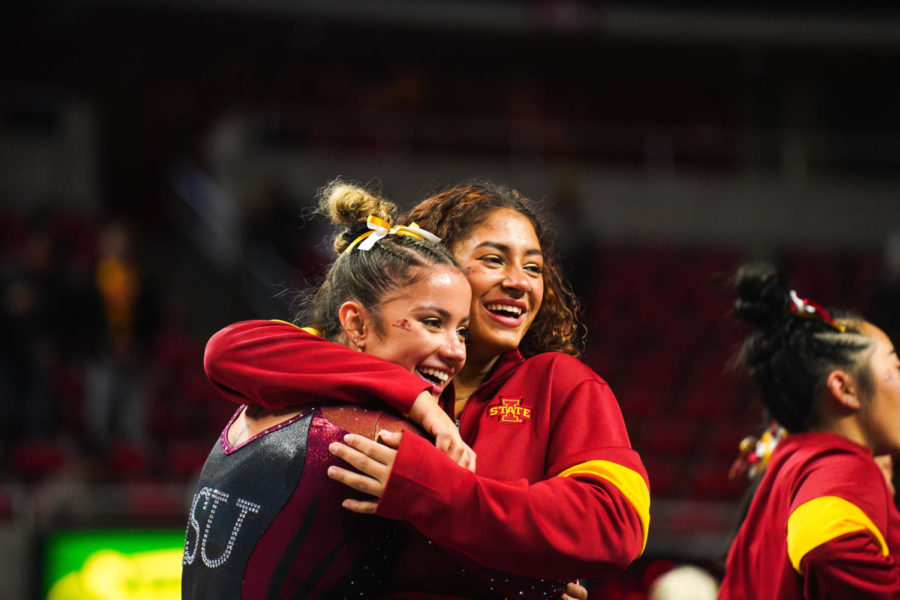 Andrea Maldonado (left) and her sister Alondra Maldonado (right) hug after the floor exercise in the Cyclones meet against the University of West Virginia on Jan. 28.