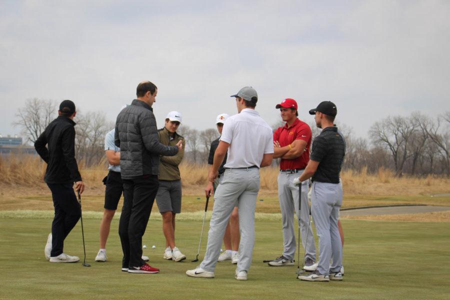Coach Andrew Tank talks with the mens golf team at practice April 5, 2019.