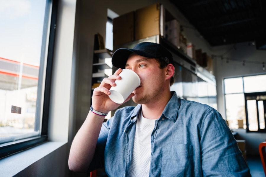 Mark Campbell, a barista at Burgies, takes a sip of coffee while looking out the window. 