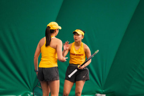 Thasaporn Naklo talks with her doubles partner Christin Hsieh in the Cyclones match against the Oklahoma Sooners April 8, 2022.