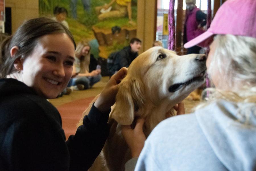 Olivia Monk a sophomore in marketing (right), Kate Lalonde, a sophomore in business analytics (left) and Jammer, a golden retriever, pictured sharing a moment during Barks@Parks Wednesday afternoon.