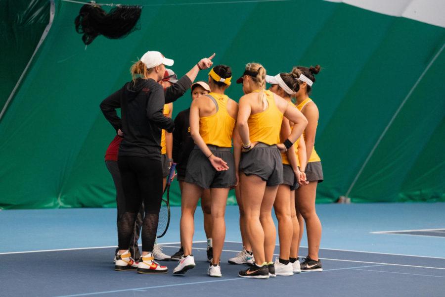 Members of the Iowa State tennis team huddle together during the Cyclones match against the Oklahoma Sooners April 8.