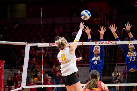 Eleanor Holthaus hits the ball over a row of blockers against Northern Iowa on Sept. 13.