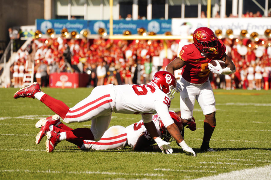 Running back Cartevious Norton pushed out of bounds by a pair of Oklahoma Sooners on Oct. 29.