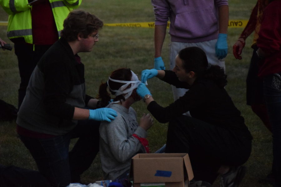 Joey Aldrich pictured providing medical assistance to a victim of the mock tornado, who was afflicted with shards of glass stuck in her face.