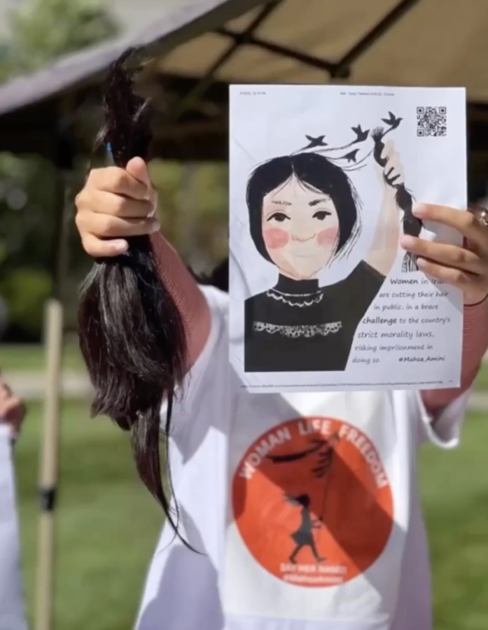 Protestor cuts hair in support of Iranian women.
