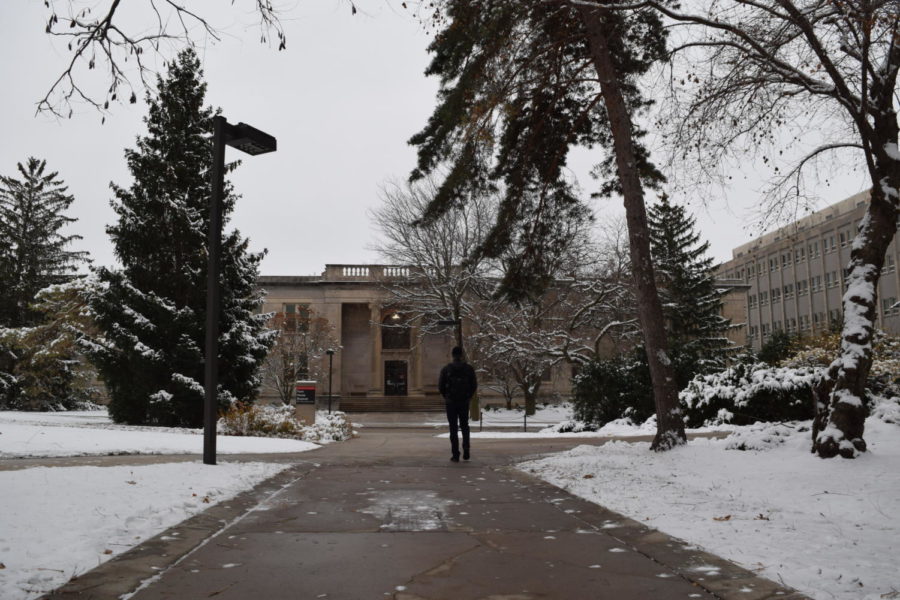 A student strolling through campus after the first snow of the 2022 fall semester.