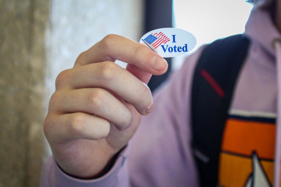 Will Custis holds up his I Voted sticker at Maple Residence Hall on Tuesday Nov. 8, 2022.
