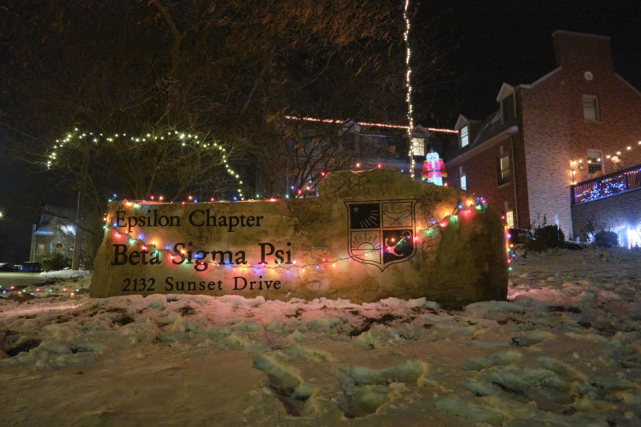 The Beta Sigma Psi house sign lit up with a string of multi-colored Christmas lights. 