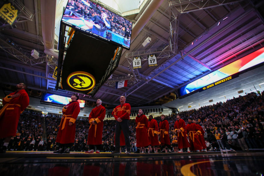 The Cyclones wrestling team stands during the national athelm before facing off with Iowa on Dec. 4, 2022.