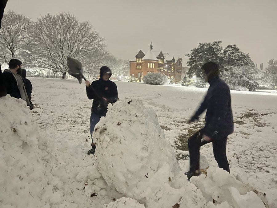Students roll large snowballs to  build the snowman on central campus Jan. 18, 2023.