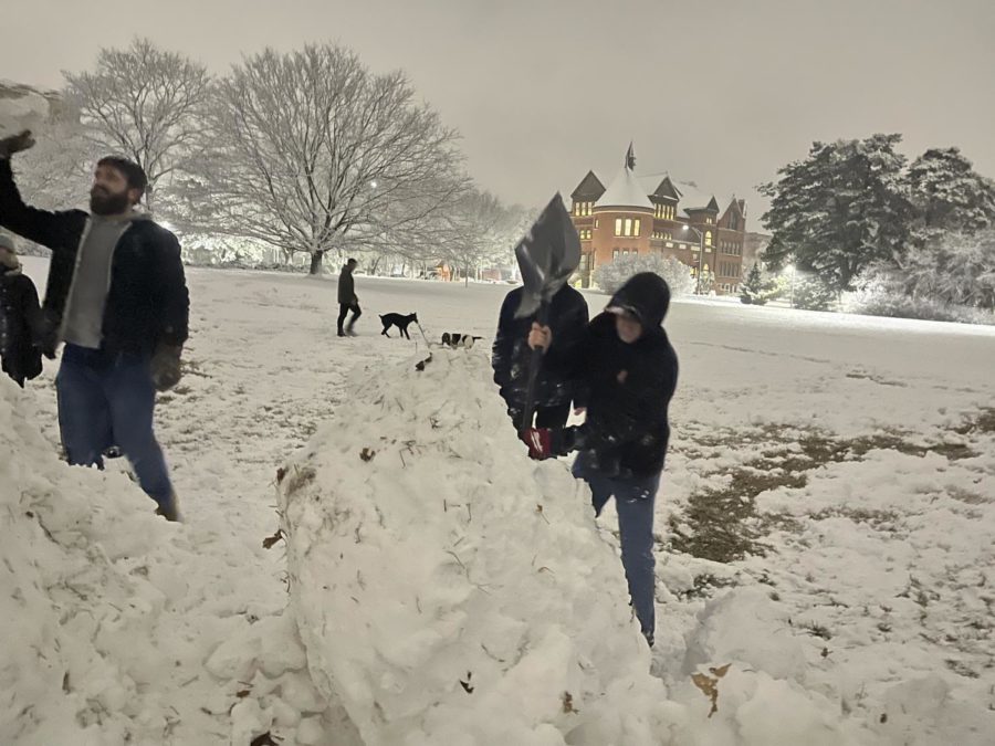 Students roll large snowballs to  build the snowman on central campus Jan. 18, 2023.