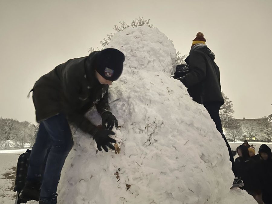 Students pat down the sides of the snowman on central campus. Jan. 18, 2023