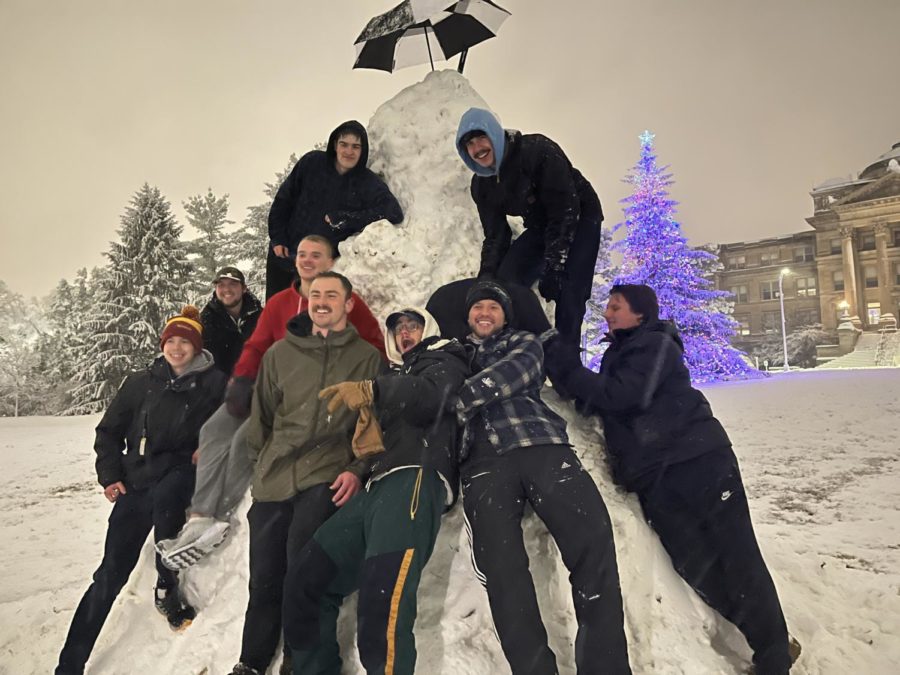 Students pose in front of the completed snowman on central campus Jan. 18, 2023. 