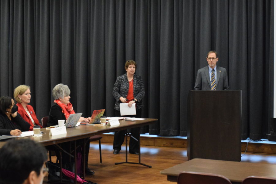 Senior Vice President and Provost Jonathon Wickert pictured standing at the podium during his presentation on Iowa States proposed list of peer institutions as Director of Institutional Research Karen Zunkel stands by.
