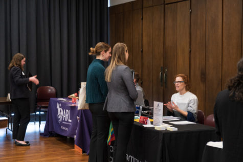 Ames Community Arts Council pictured talking with two students at the People to People Career Fair in Memorial Unions Great Hall. 