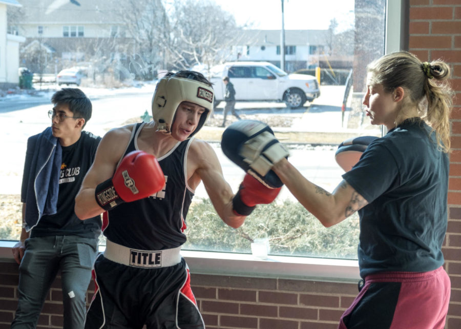 Iowa State student Will Griner warms up with boxing club coach Liv Meyer before his match-up. Meyer was the first ISU female boxer to compete and bring home the title in the National Collegiate Boxing Association National Championships in 2014 when she was a member of the club. 