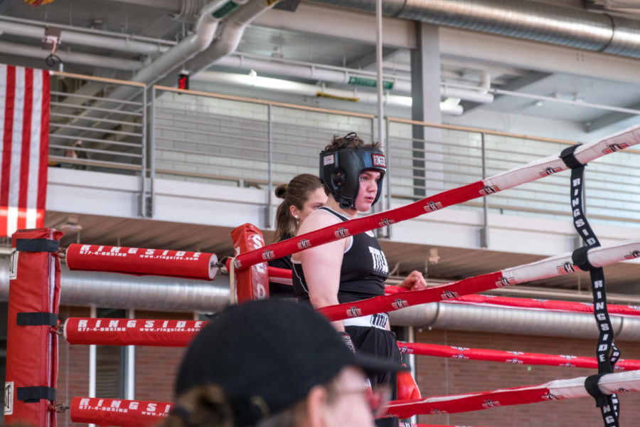 Michale Cahir, a junior at Iowa State studying physics getting ready for his first fight. (Coach Liv Meyer pictured outside the ring)