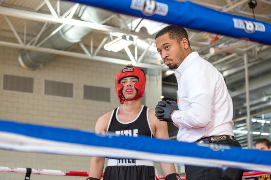 Iowa State student Izzat Azmi listens for instructions from the referee before boxing in his match. Azmi is a senior in marketing. 