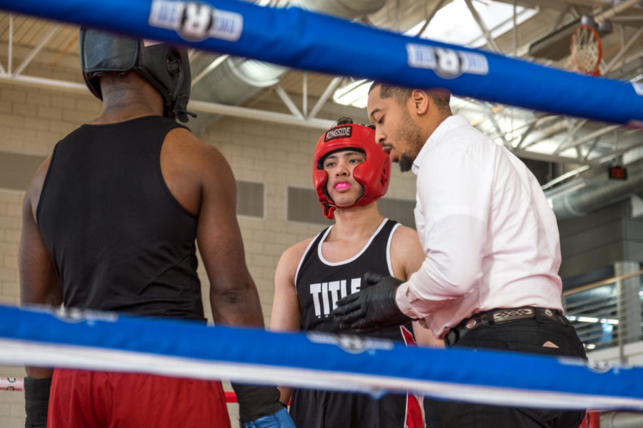 Iowa State student Izzat Azmi listening for instructions from referee before boxing match 