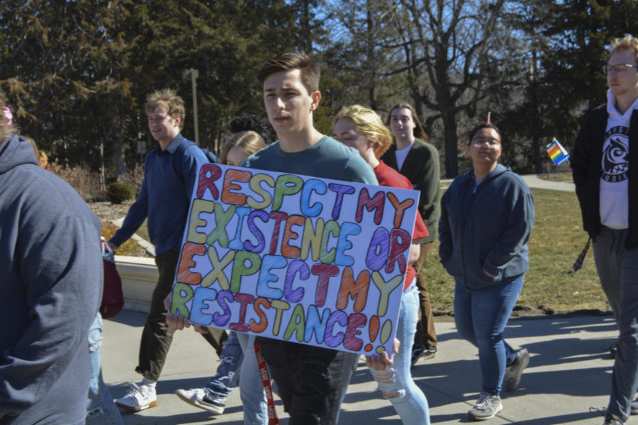 Mason Holmen, an English education major, holds a sign while participating in the LGBTQIA+ walkout on March 1, 2023.