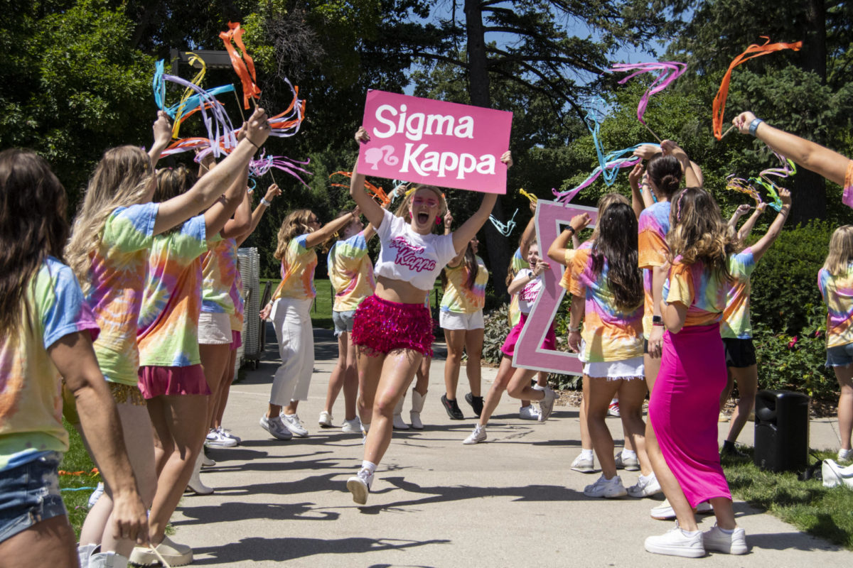 Sigma Kappa representatives run through a tunnel of Rho Gamma members during the Collegiate Panhellenic Council Bid Day on Thursday, Aug. 17, 2023, at Iowa State’s central campus in Ames.