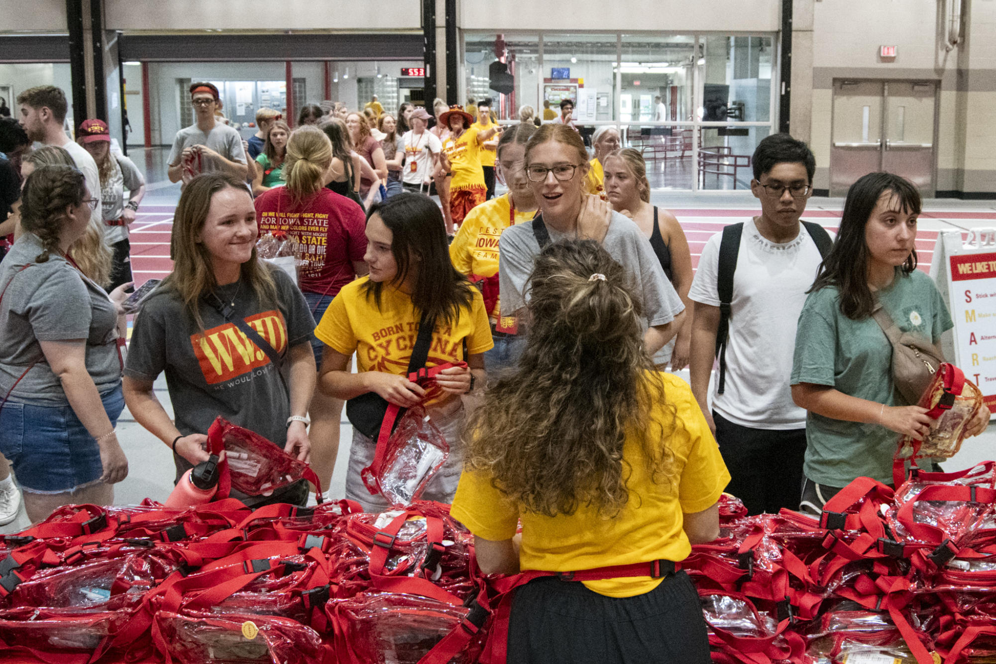 New Iowa State students arrive a pick up their complimentary belt bag with different items inside during the Cyclone Welcome Weekend Cookout on Friday at the Lied Recreation Athletic Center in Ames.