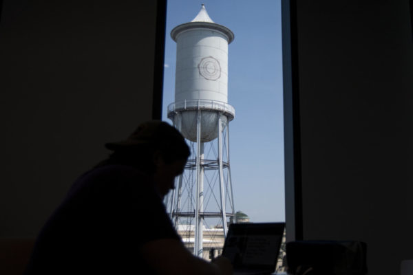Achilles Seastrom works by a window with a view of the Marston Water Tower on Tuesday, Aug. 29, 2023, at Iowa State’s Student Innovation Center in Ames.