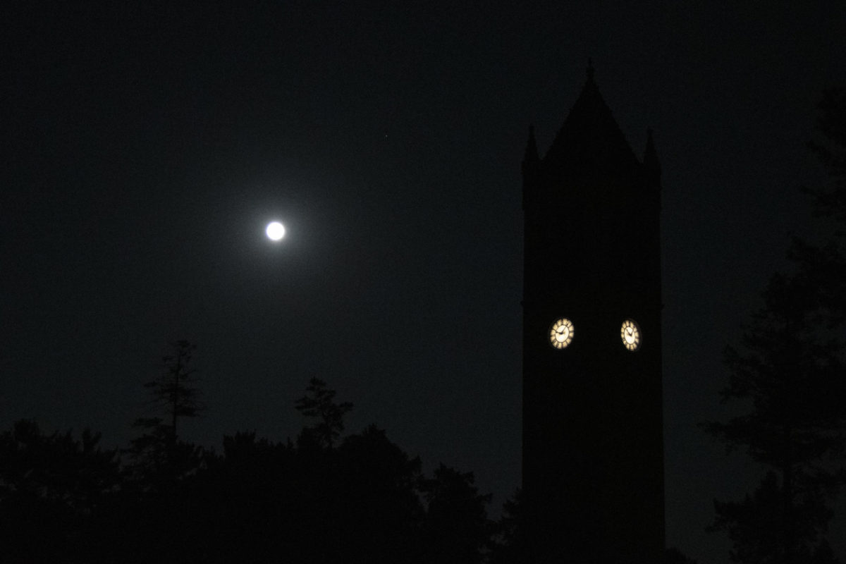 A rare blue supermoon brightens the night sky behind the Campanile on Wednesday, Aug. 30, 2023, at Iowa State University in Ames, Iowa. Saturn is sitting to the right of the moon, also glowing bright.